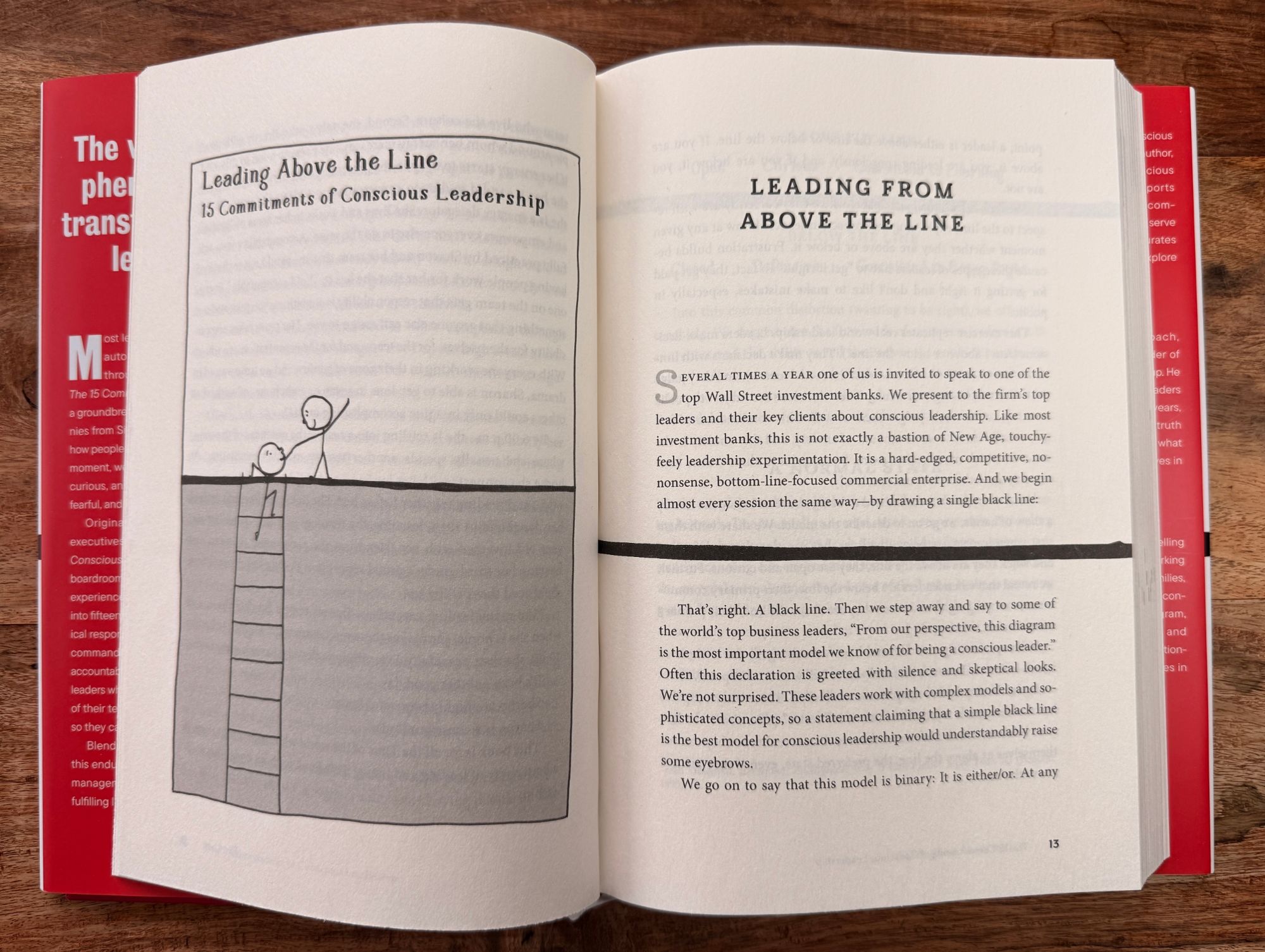 The book open on a wooden table to the Leading Above the Line chapter, showing the stick-figure illustration of above and below the line.